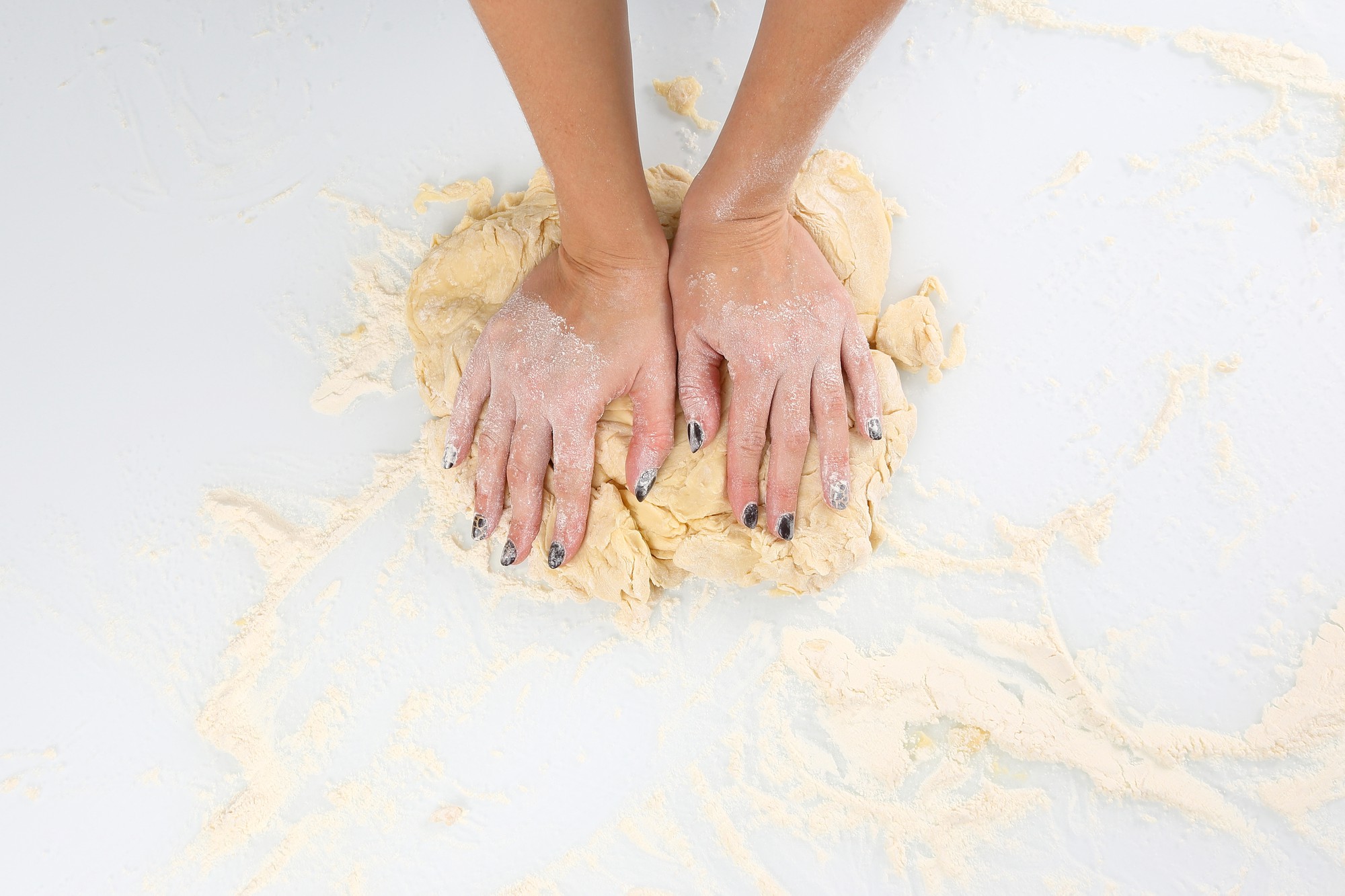 Dettaglio mani che impastano pasta fresca